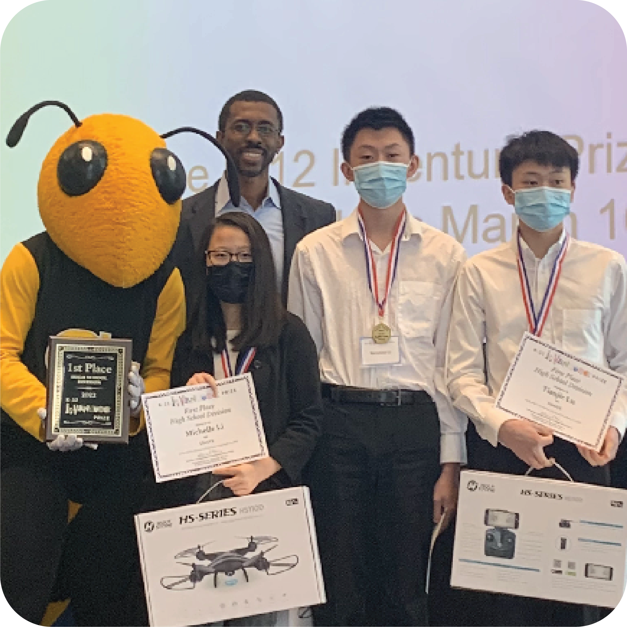 Three smiling students holding prizes and standing next to Buzz (Georgia Tech's yellowjacket mascot) holding a plaque and Craig Cupid (Georgia Intellectual Property and Alliance representative).